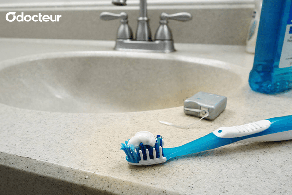 une brosse à dents et un fil dentaire, soulignant l'importance de l'hygiène bucco-dentaire.