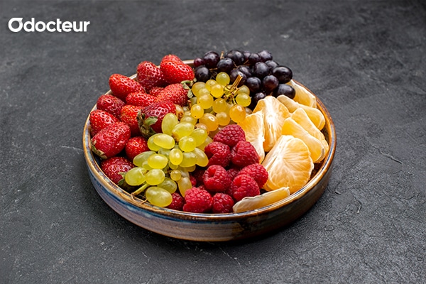 Un bol rempli d'une variété de fruits exotiques et de baies rouges, riches en antioxydants et en vitamines pour renforcer l'immunité.